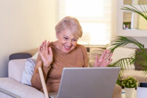 Happy mature woman chatting on computer